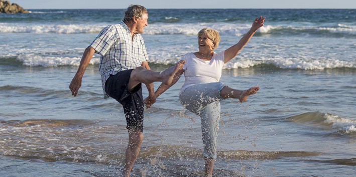 Casal de idosos se divertindo no mar